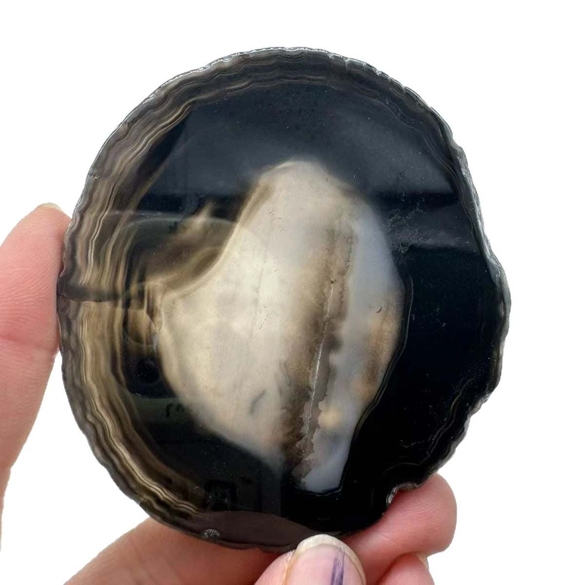 Natural agate slice coaster, 8-10 cm, held in a hand for scale