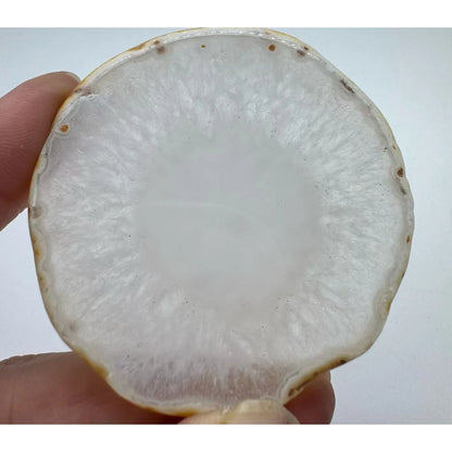 Natural agate slice coaster, 8-10 cm, held in a hand for scale